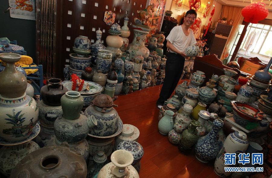 胡平展示专门发行的《中华文化名家胡平古陶瓷鉴赏收藏艺术成就邮票、明信片、纪念珍藏册》（9月16日摄）。