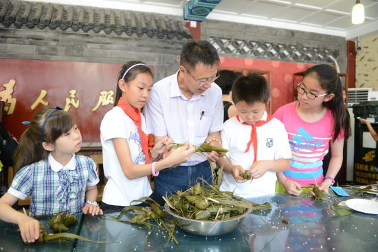“北京榜样”王伟力指导孩子们包粽子