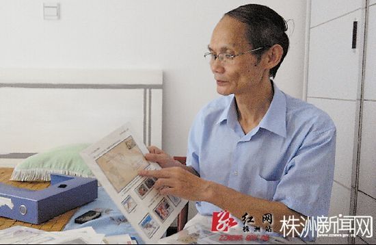 杨宏老先生对自己的邮票如数家珍。李军/摄