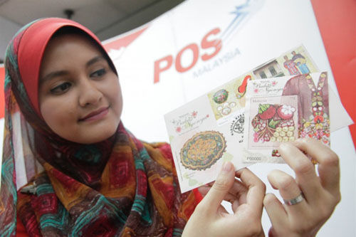 大马邮政公司职员展示最新峇峇娘惹主题性邮票、小型张邮票及首日封，仅于11月29日当天出售。