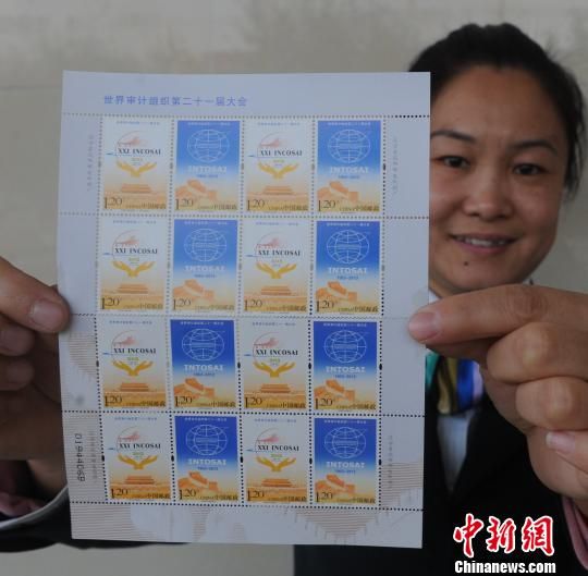 图为河北省大厂回族自治县邮政局工作人员向记者展示《世界审计组织第二十一届大会》纪念邮票。　刘亮　摄