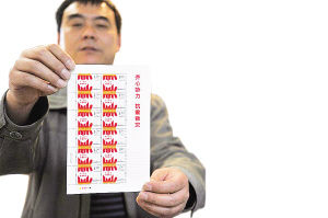 山东省济南市邮票公司的工作人员在展示《齐心协力 抗震救灾》邮票
